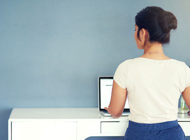 Woman sits at a desk typing