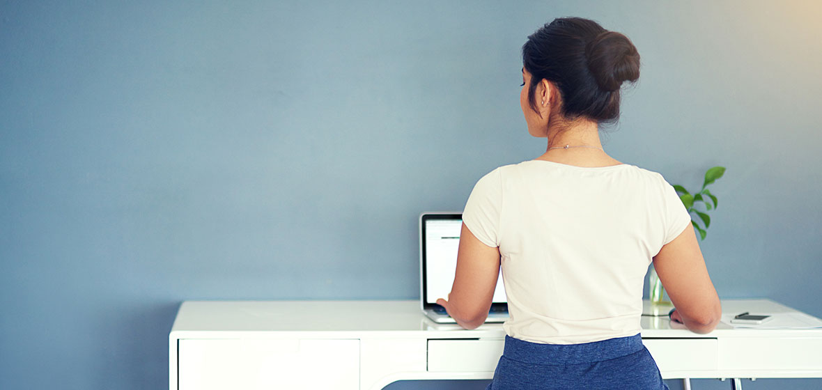 Woman sits at a desk typing