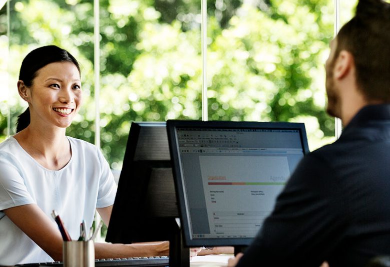 Man and woman using computers in an office