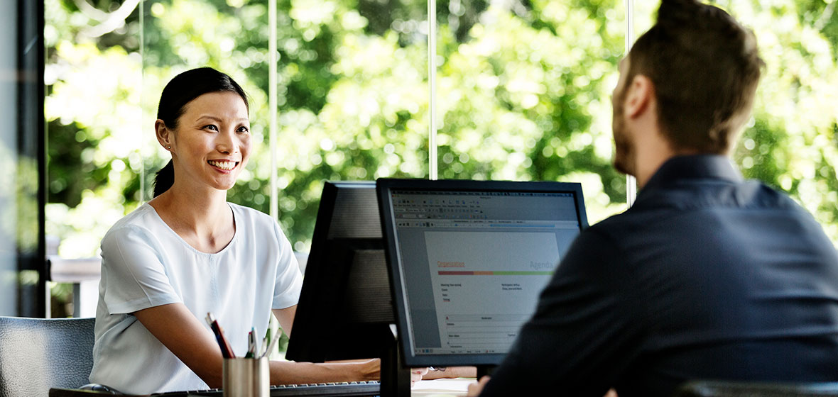 Man and woman using computers in an office