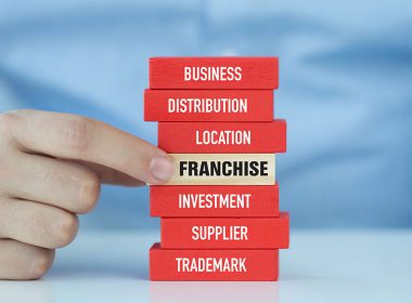 Blocks of wood with words business, distribution, location, franchise, investment, supplier, trademark on the sides