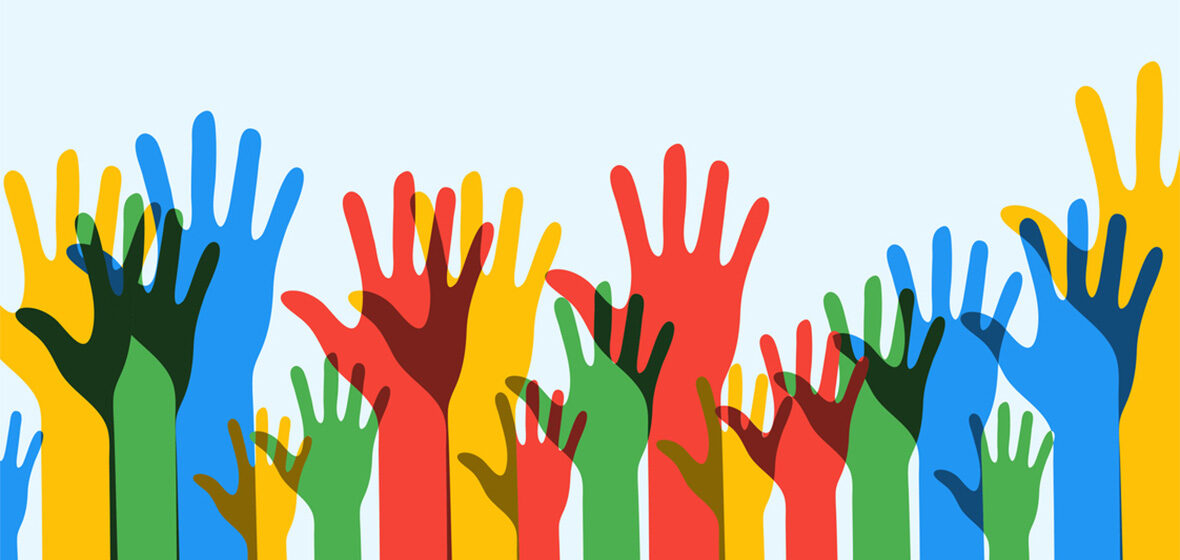 photo of hands of different colours raised to show progressive voting trends
