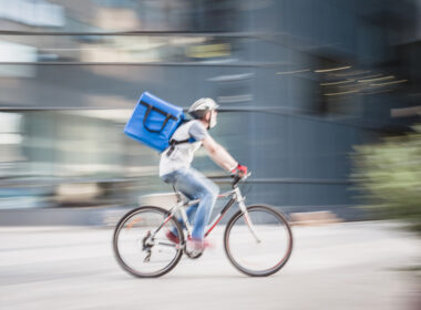 photo of cyclist with parcel speeding to show dangers of gig economy