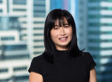 photo of Leanne Ho in frnt of a window overlooking city buildings