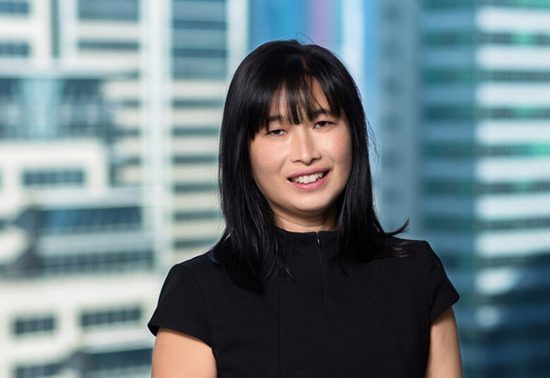 photo of Leanne Ho in frnt of a window overlooking city buildings