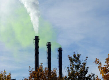 photo of factory with green smoke from chimneys to show greenwashing